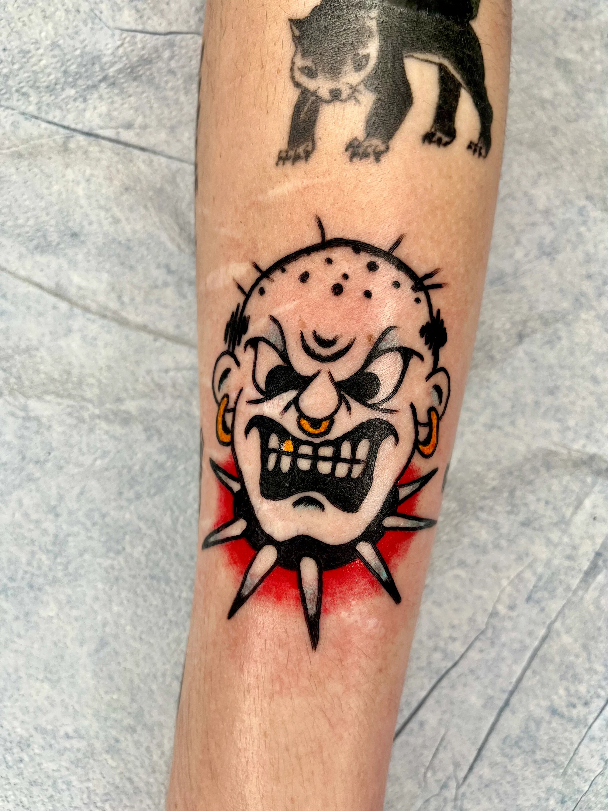 Traditional spiked skull tattoo on forearm